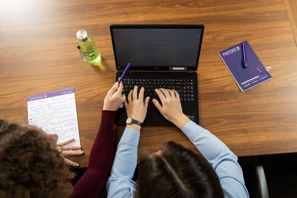 Afbeelding van iemand die aan het typen is op een laptop